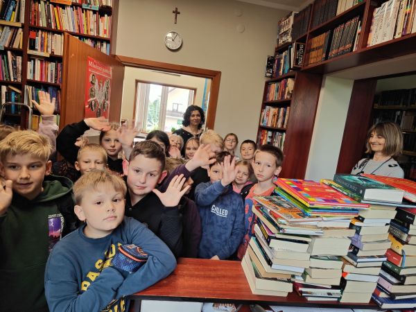 zdjęcie przedstawia grupę uczniów z opiekunami w bibliotece
