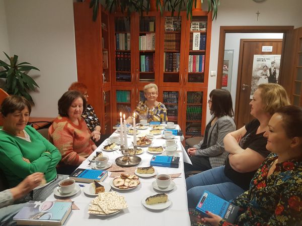 na zdjęciu widoczna grupa kobiet w różnym wieku siedzących przy zastawionym stole