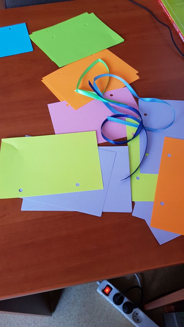 kolorowe kartki papieru i kolorowe wstążki na blacie