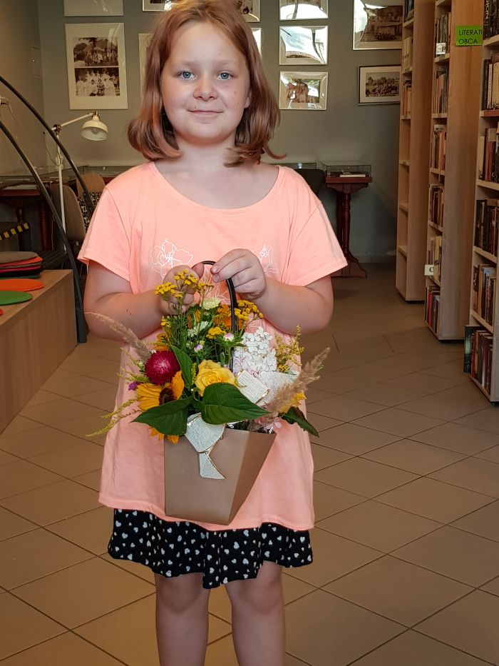 na zdjęciu widoczna dziewczynaka z bukietem kwiatów w rękach