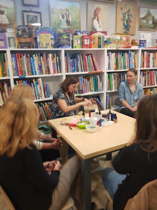 zdjęcie przedstawia grupę kobiet siedzących przy stoliku podczas warsztatów w bibliotece