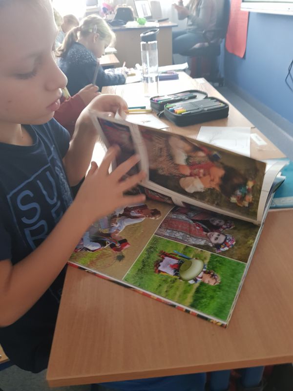 zdjęcie przedstawia chłopca przeglądającego książkę