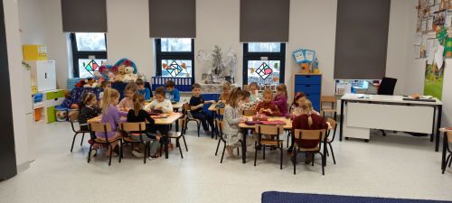 sala szkolna, w oddali widoczne dzieci przy stolikach