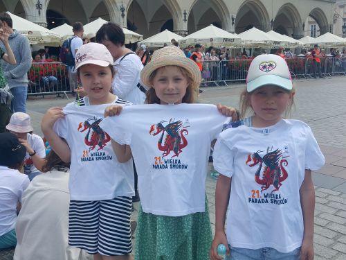 zdjęcie przedstawia trzy dziewczynki w pamiątkowych koszulkach z parady smoków