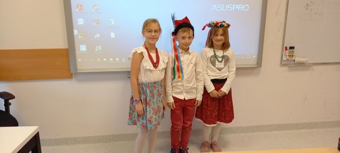 zdjecie przedstawia troje uczniów ubranych w elementy stroju krakowskiego