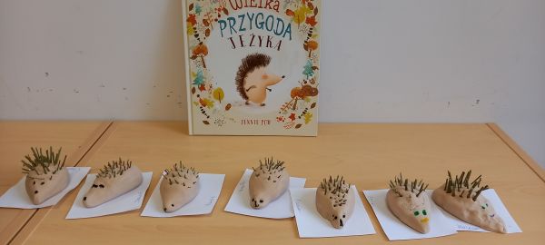 na zdjęciu widoczne jeże wykonane przez dzieci, w tle książka o jeżu