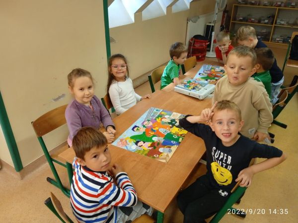 na zdjęciu widoczna grupa dzieci siedząca przy stoliku podczas zajęć