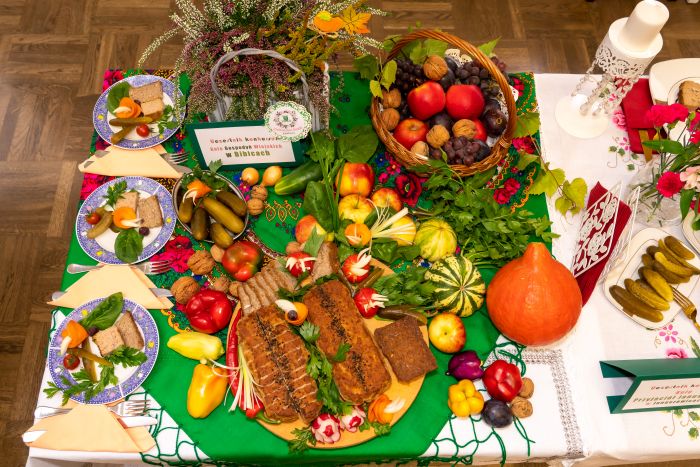 zdjęcie przedstawia różne produkty spożywcze leżace wraz z dekoracjami jesiennymi na stole