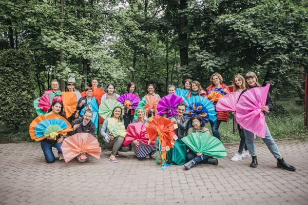zdjęcie grupy osób z dużymi kolorowymi wachlażami