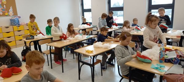 zdjęcie przedstawia uczniów siedzących w ławkach w klasie podczas zajęć