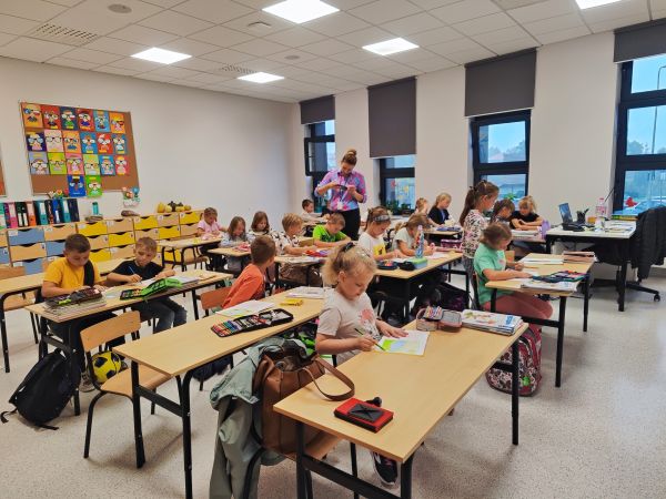 zdjęcie przedstawia dzieci siedzące w klasie podczas lekcji