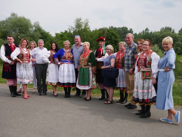 zjęcie plenerowe grupy osób, część z nich ubrana jest w stroje krakowskie