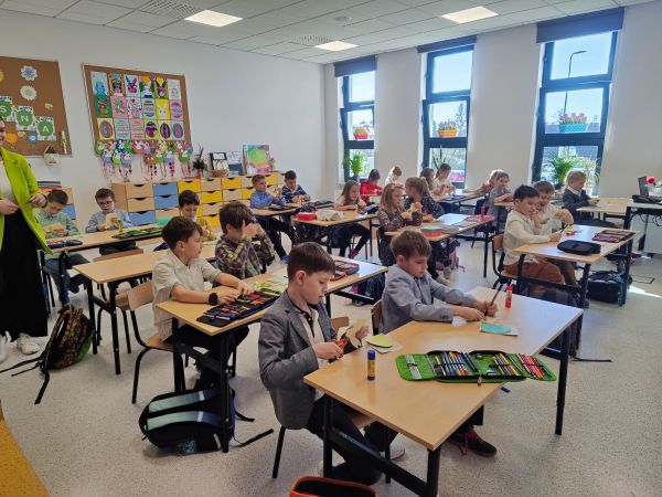 zdjęcie przedstawia uczniów siedzących w klasie podczas zajęć