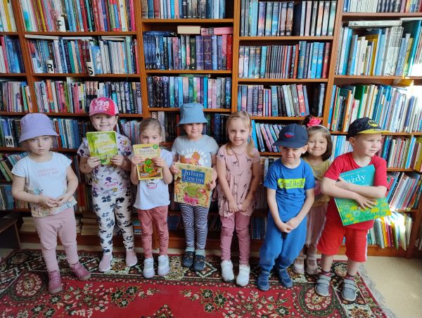 zdjęcie przedszkolaków na tle regału z książkami